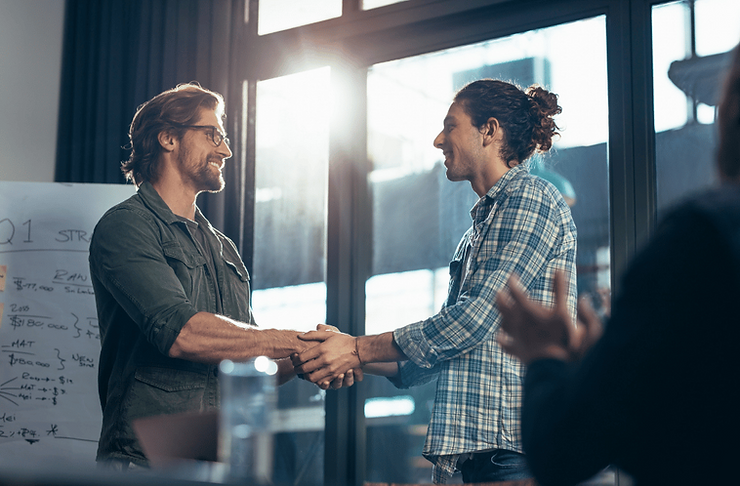 Pemilik usaha mengapresiasi karyawannya dalam sebuah meeting, mencerminkan growth mindset.