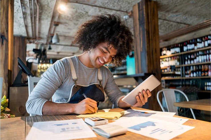 Karyawan tengah membuat laporan pembukuan kasir restoran.