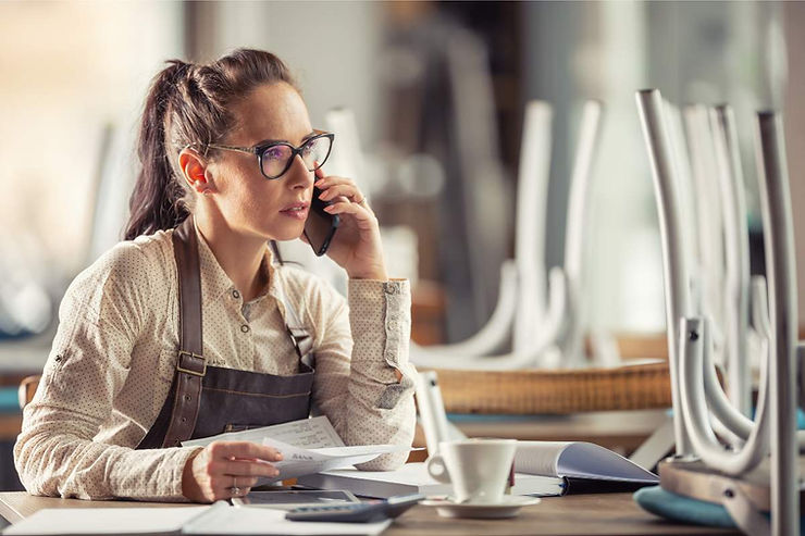 Karyawan cek laporan pembukuan kasir restoran ketika tutup.
