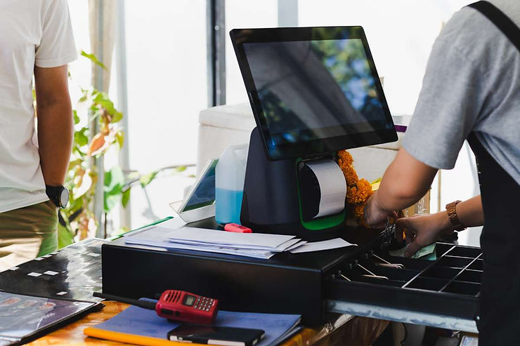 Kasir sedang memberikan uang kembalian yang tersimpan di cash drawer.