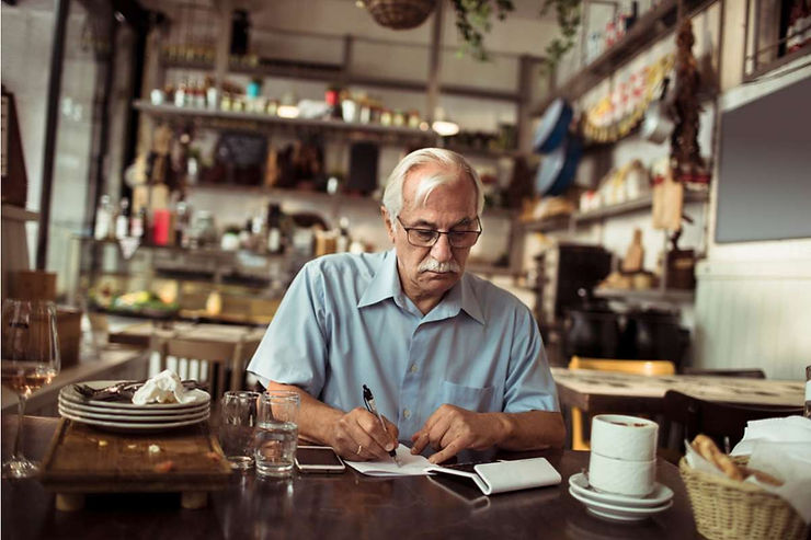 Pemilik bisnis sedang mengecek penjualan dengan smartphone untuk aplikasi kasir Android.