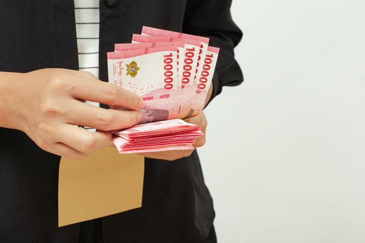 Pemilik bisnis sedang menghitung biaya bahan baku.